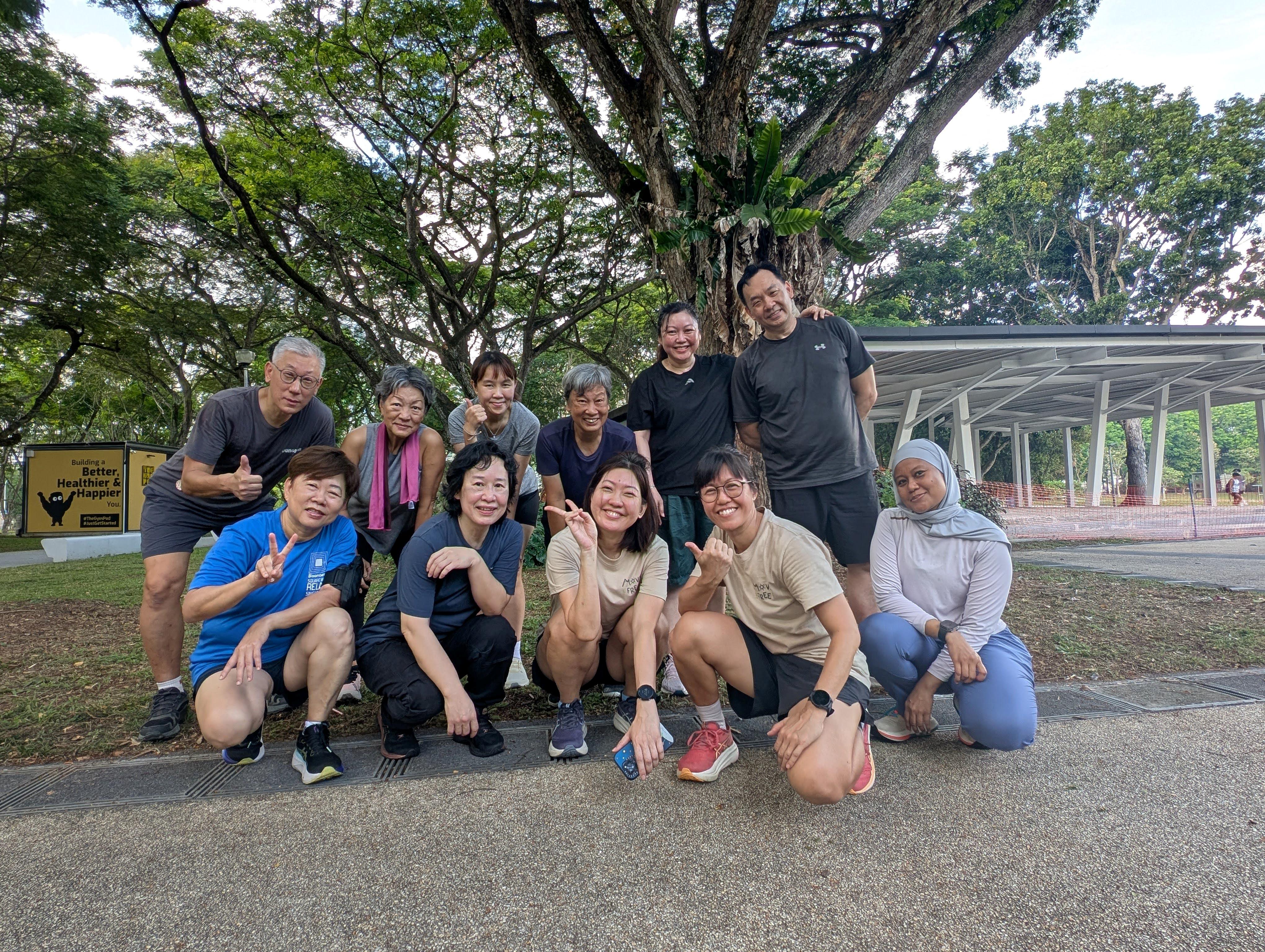Liza with a group of Move Free participants smiling together outdoors under a tree